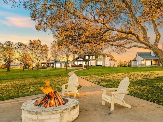 view of home's community with a yard and an outdoor fire pit