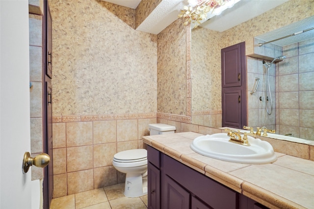 12502 Burninglog Ln, Dallas, TX 75243 - full bathroom with vanity, tiled shower, tile patterned floors, a wainscoted wall, and tile walls