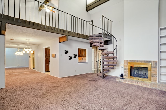 unfurnished living room featuring a brick fireplace, carpet floors, built in features, and a high ceiling