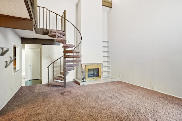 12502 Burninglog Ln, Dallas, TX 75243 - unfurnished living room with stairs, carpet flooring, a towering ceiling, and a brick fireplace