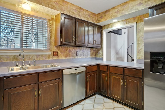 kitchen with dark brown cabinetry, sink, and appliances with stainless steel finishes