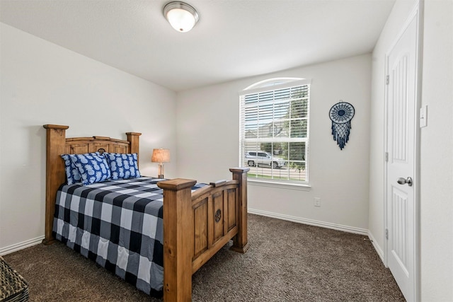 bedroom with baseboards and dark colored carpet