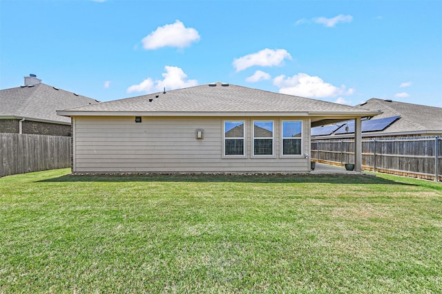 rear view of property with a yard, a patio area, a fenced backyard, and roof with shingles