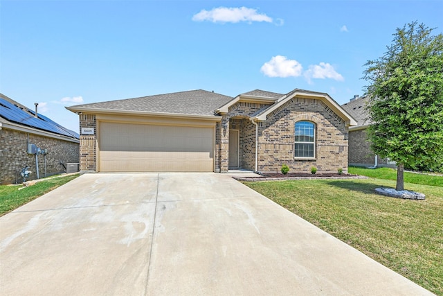 view of front of house featuring a front yard, central AC, and a garage