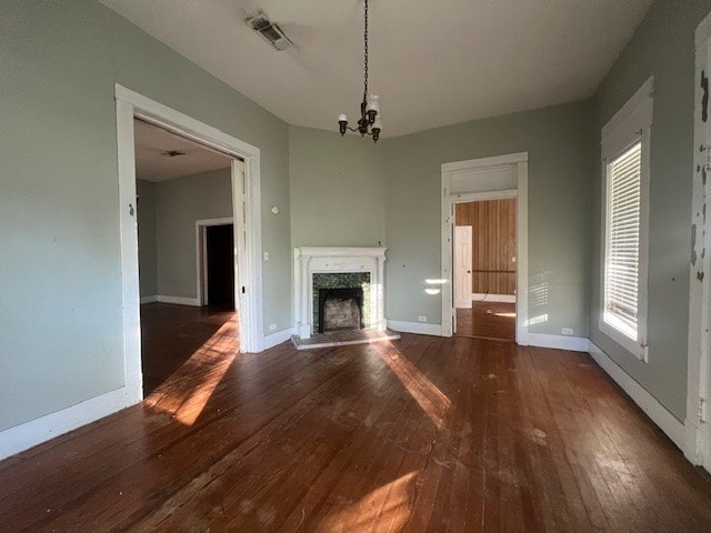 unfurnished living room with dark hardwood / wood-style flooring and a chandelier