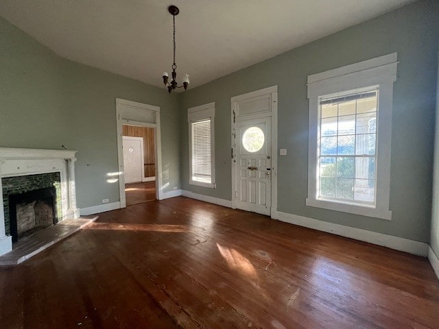 entrance foyer featuring a notable chandelier, dark hardwood / wood-style floors, and a healthy amount of sunlight