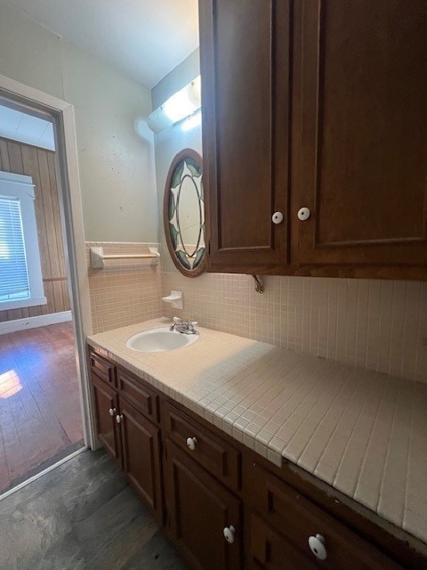 bathroom featuring hardwood / wood-style flooring, vanity, and tasteful backsplash