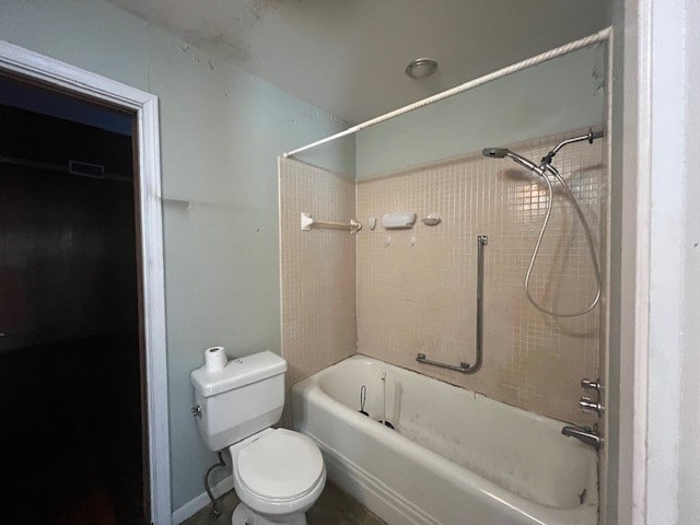 bathroom with tiled shower / bath combo and toilet