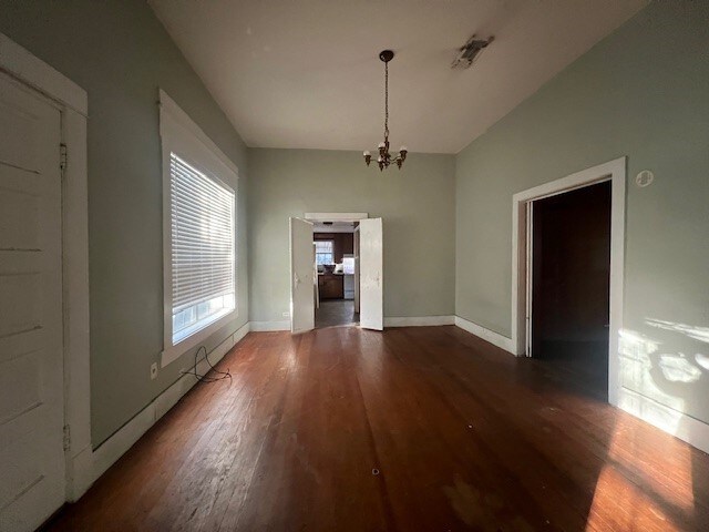 unfurnished dining area with dark hardwood / wood-style flooring and an inviting chandelier