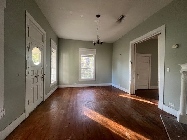 entryway featuring an inviting chandelier and dark wood-type flooring