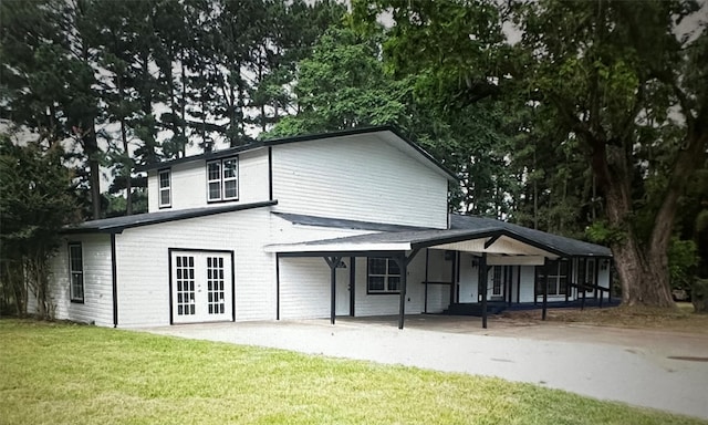 rear view of property featuring a lawn and french doors