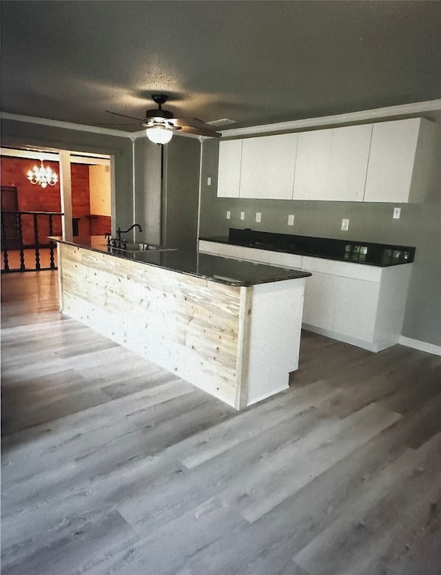 kitchen with white cabinets, ceiling fan, wood-type flooring, and sink