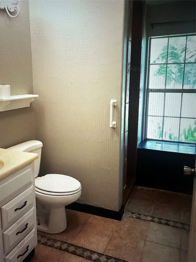 bathroom featuring tile patterned floors, vanity, and toilet