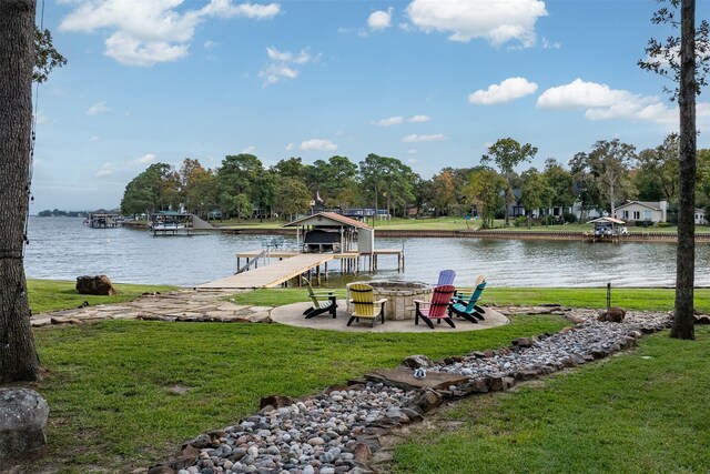 view of dock with a lawn, a water view, and boat lift