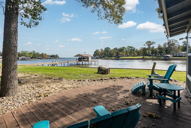 view of dock with a lawn and a water view