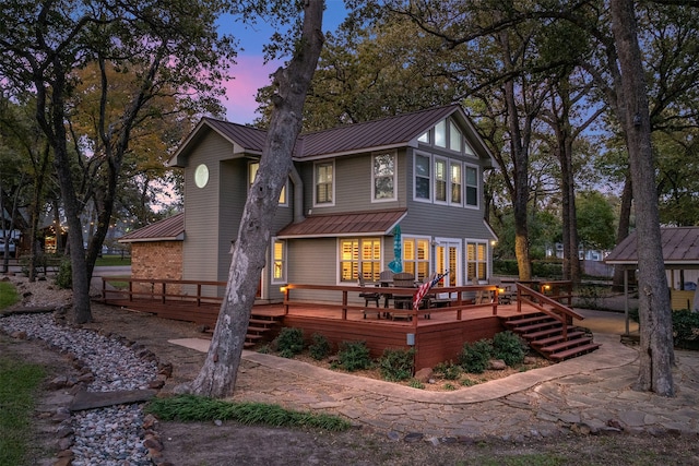 back house at dusk with a deck