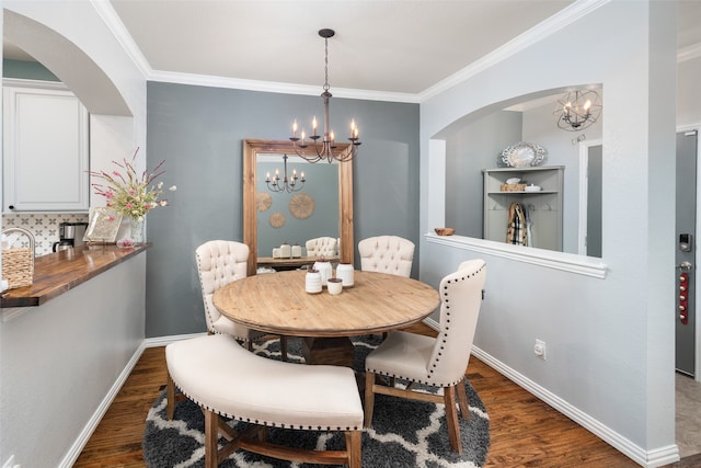 dining area with a chandelier, dark hardwood / wood-style flooring, and crown molding