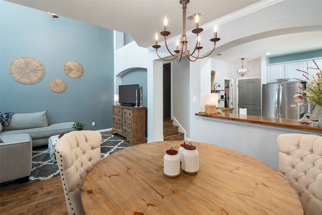 dining space with a chandelier, dark hardwood / wood-style flooring, and ornamental molding