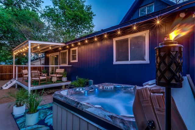 patio terrace at dusk featuring an outdoor living space and a hot tub