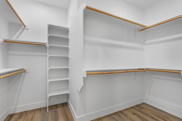 walk in closet with dark hardwood / wood-style flooring