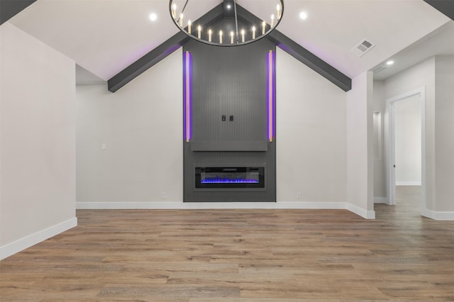 unfurnished living room with a chandelier, high vaulted ceiling, light hardwood / wood-style flooring, and a fireplace