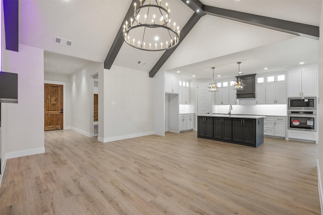 kitchen featuring appliances with stainless steel finishes, a center island with sink, light hardwood / wood-style flooring, white cabinetry, and hanging light fixtures