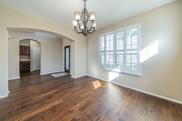 empty room featuring dark hardwood / wood-style floors and an inviting chandelier