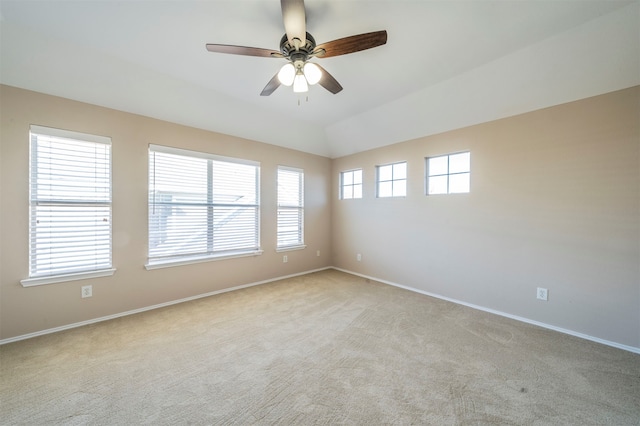 carpeted empty room featuring ceiling fan, a healthy amount of sunlight, and vaulted ceiling