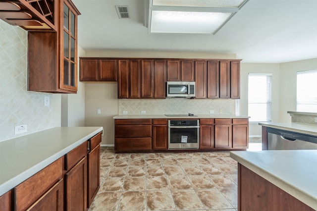 kitchen with appliances with stainless steel finishes and backsplash