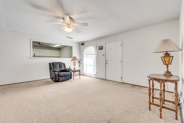 living area featuring carpet flooring and ceiling fan