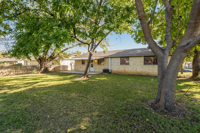 rear view of property with a yard, a patio, and central AC unit