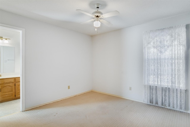 empty room featuring ceiling fan, a healthy amount of sunlight, and light colored carpet