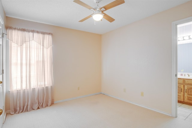 carpeted spare room with ceiling fan and sink