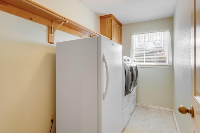 laundry area featuring washer and clothes dryer and cabinets