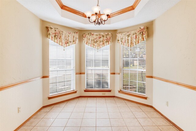 empty room with an inviting chandelier, crown molding, and a tray ceiling