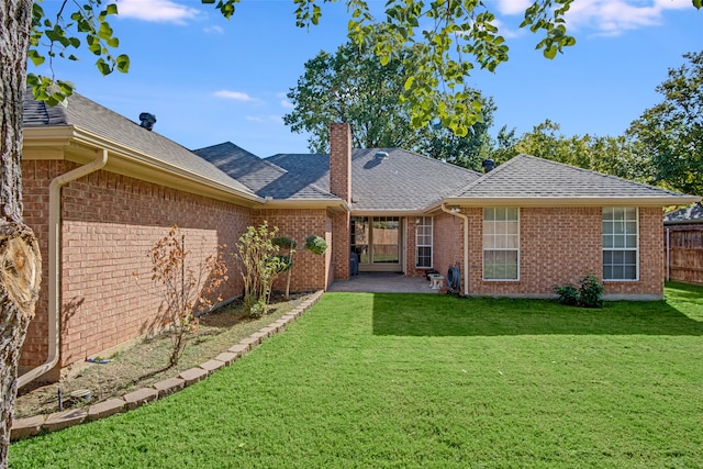 rear view of house featuring a lawn