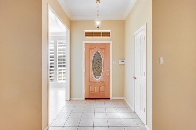 foyer entrance with light tile patterned flooring and ornamental molding