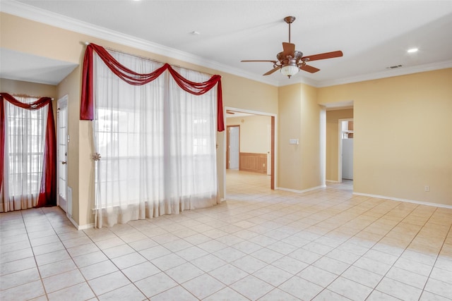 spare room featuring ceiling fan, ornamental molding, and light tile patterned floors