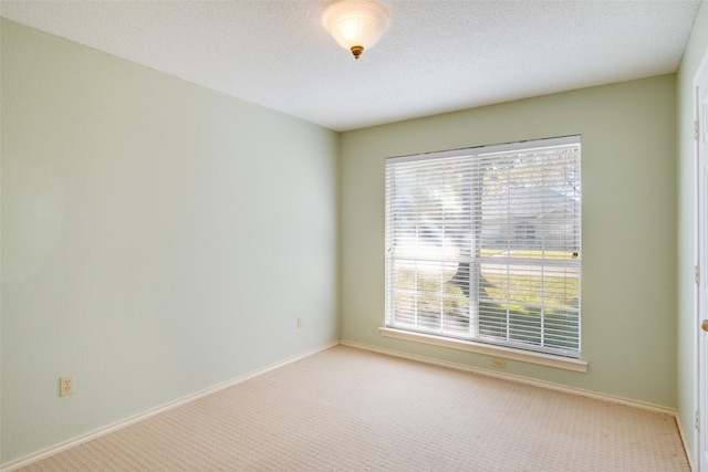 carpeted empty room featuring a textured ceiling