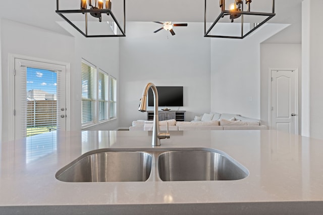 kitchen featuring sink and ceiling fan with notable chandelier