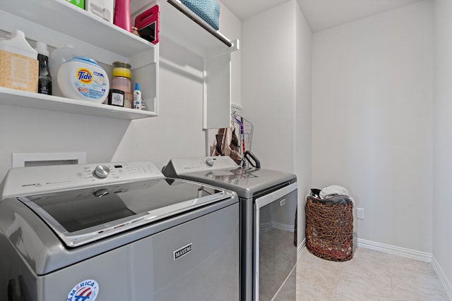 laundry room with light tile patterned floors and washer and dryer