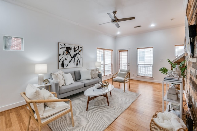 living room with light wood-type flooring, ceiling fan, and crown molding