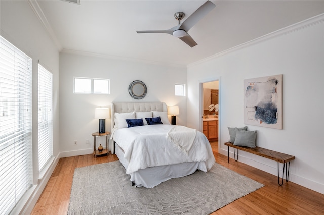 bedroom featuring connected bathroom, light hardwood / wood-style floors, ceiling fan, and ornamental molding