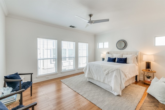 bedroom with ceiling fan, crown molding, and light hardwood / wood-style floors