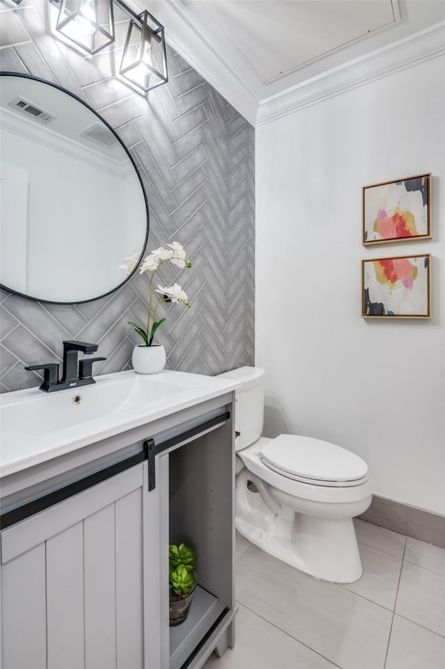 bathroom with vanity, tile patterned floors, crown molding, toilet, and tasteful backsplash