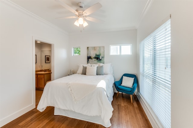 bedroom featuring hardwood / wood-style floors, connected bathroom, ceiling fan, and crown molding