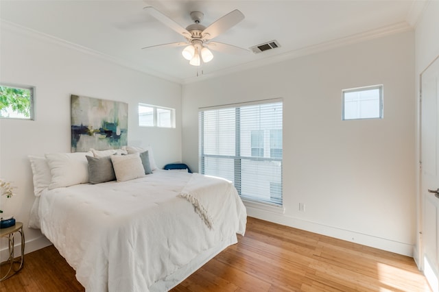 bedroom featuring hardwood / wood-style flooring, ceiling fan, and ornamental molding