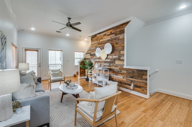 living room with ceiling fan, wood-type flooring, and ornamental molding