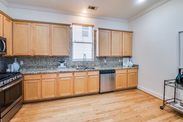 kitchen with sink, light stone countertops, stainless steel appliances, and light hardwood / wood-style flooring