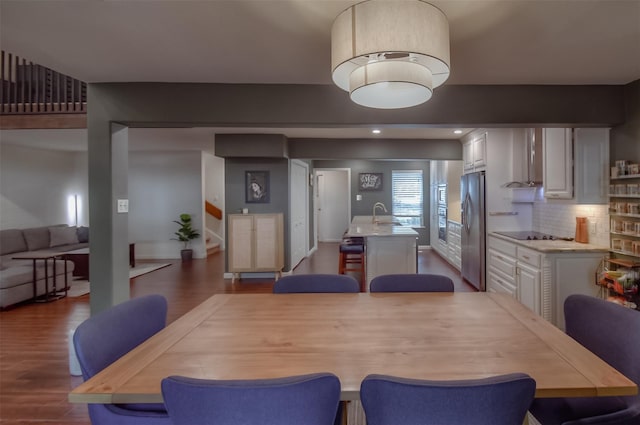 dining area featuring sink and dark wood-type flooring